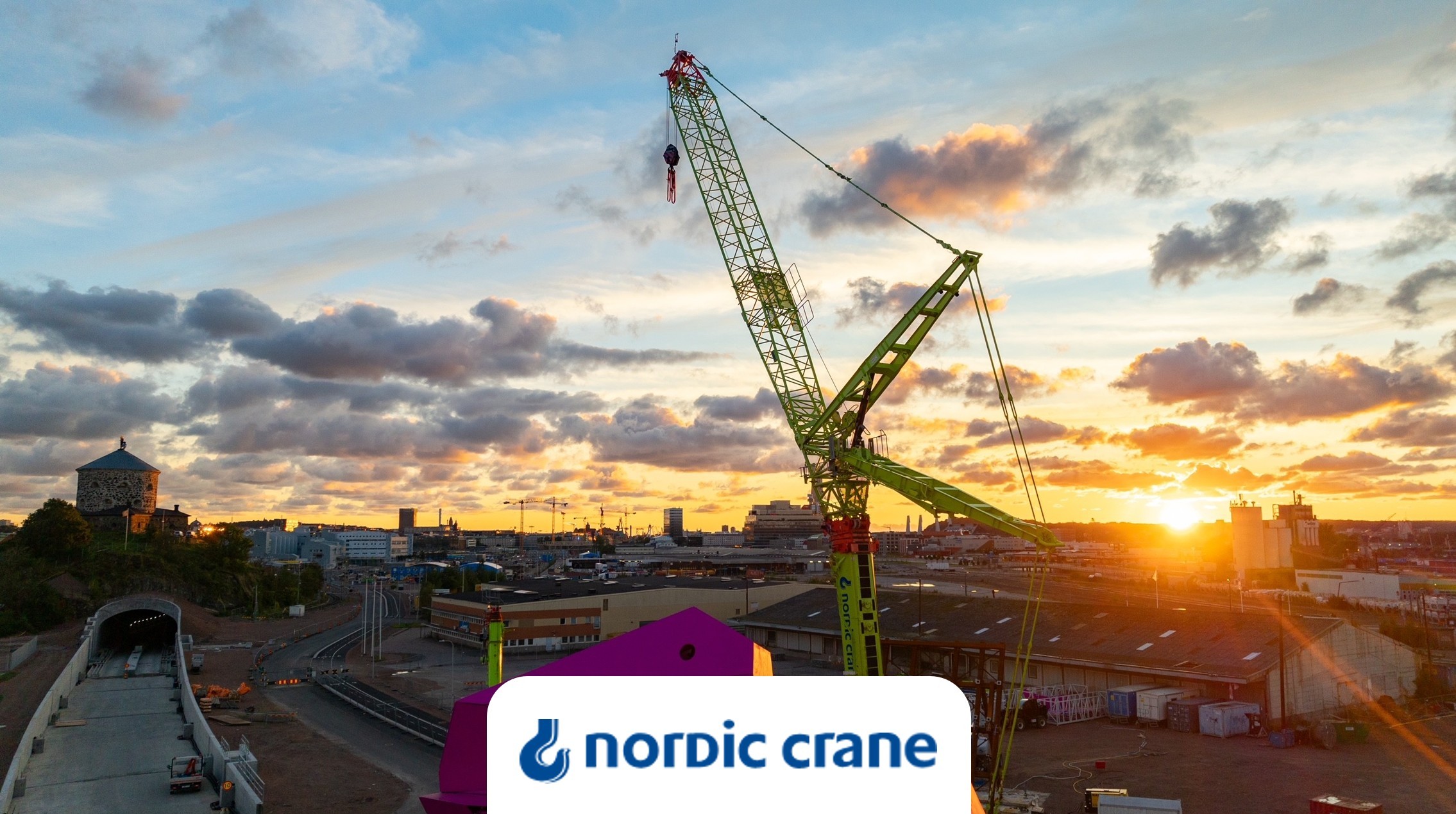 En av Nordic Cranes kranar på en byggarbetsplats i solnedgång.